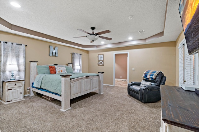 bedroom featuring a tray ceiling, ceiling fan, carpet flooring, and a textured ceiling