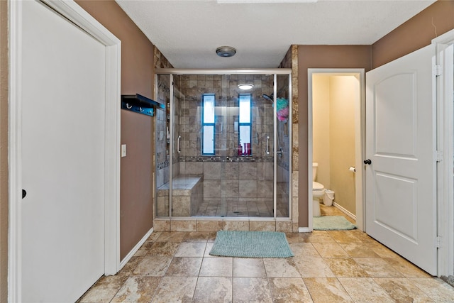 bathroom with walk in shower, a textured ceiling, and toilet