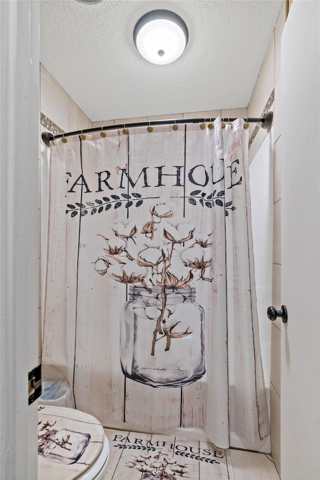 bathroom with a shower with curtain and a textured ceiling