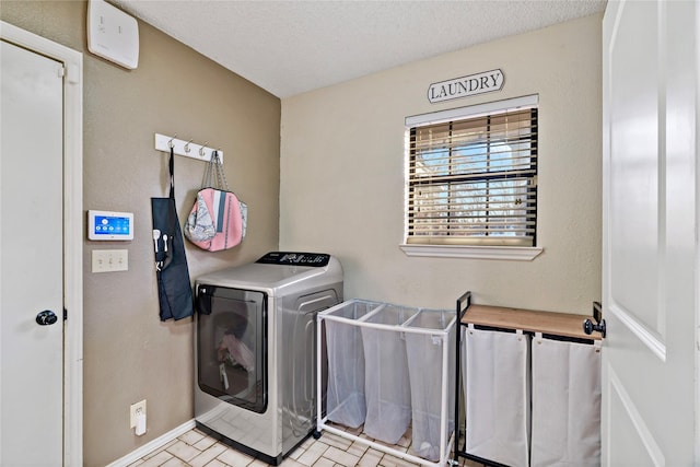 washroom with washing machine and dryer and a textured ceiling