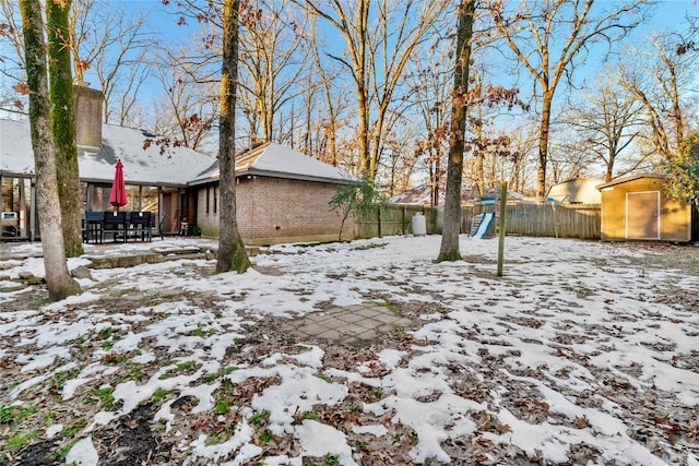 yard layered in snow featuring a playground