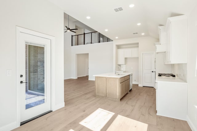 kitchen with a center island with sink, visible vents, ceiling fan, light wood-type flooring, and dishwasher