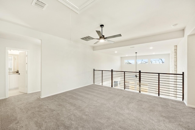 spare room with ceiling fan, carpet, visible vents, and attic access