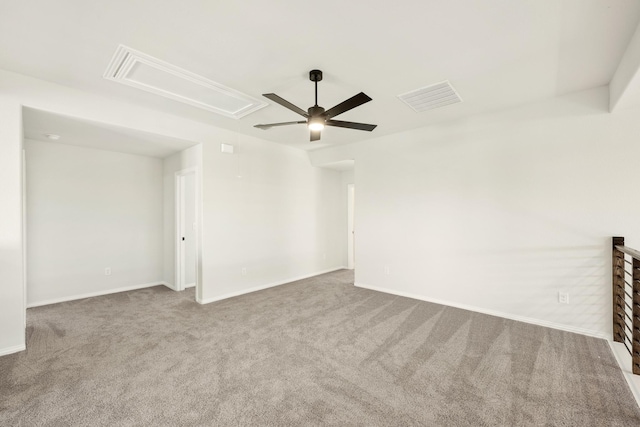 empty room with visible vents, attic access, a ceiling fan, carpet flooring, and baseboards