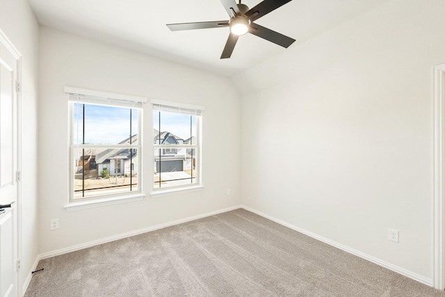 carpeted empty room with lofted ceiling, ceiling fan, and baseboards