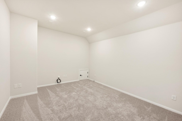 spare room with carpet flooring, recessed lighting, baseboards, and vaulted ceiling