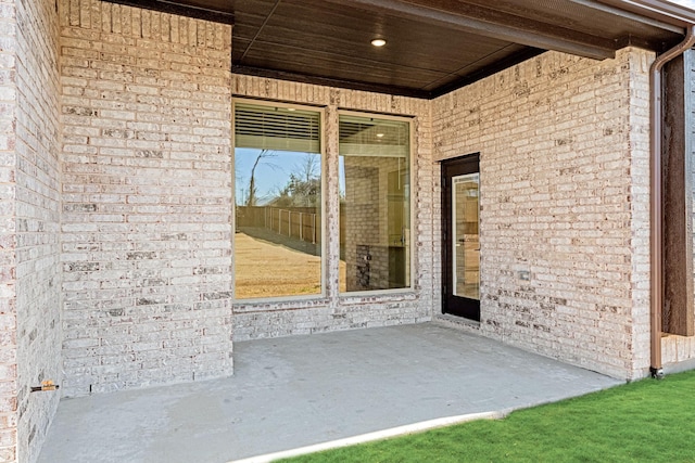 doorway to property with a patio area and brick siding