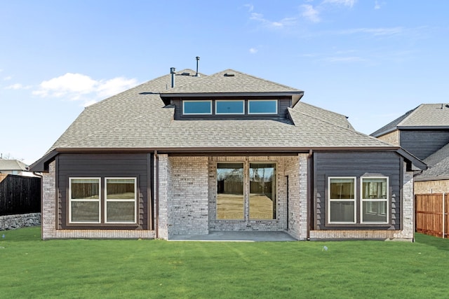 rear view of property featuring a yard, a patio area, roof with shingles, and fence