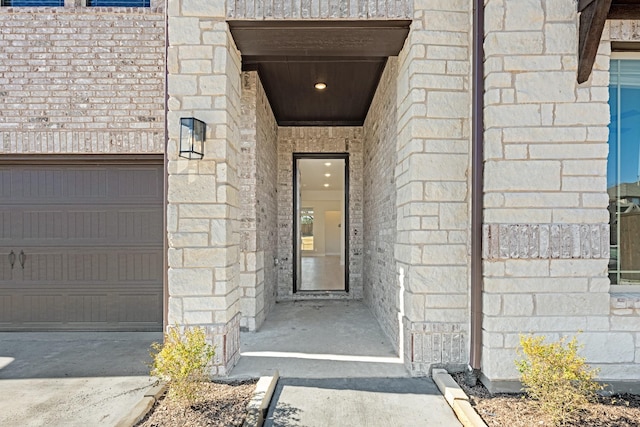 property entrance featuring stone siding and a garage