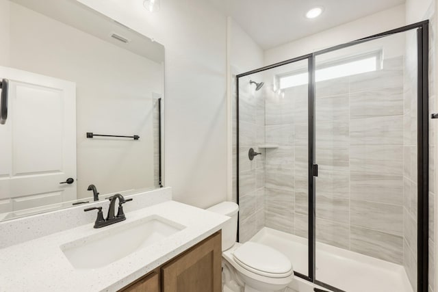 bathroom featuring visible vents, vanity, a shower stall, and toilet