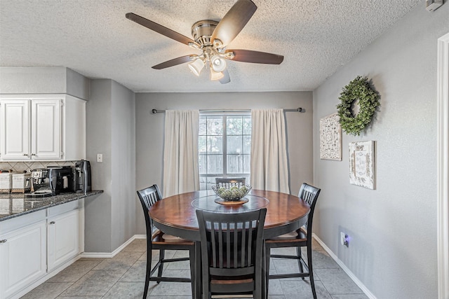 tiled dining room with ceiling fan and a textured ceiling