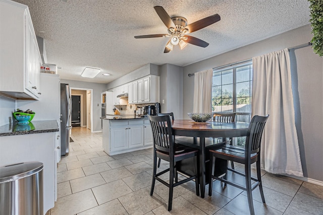 dining room with a textured ceiling, ceiling fan, and light tile patterned floors