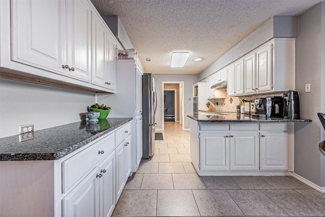 kitchen featuring white cabinets, kitchen peninsula, stainless steel appliances, and light tile patterned flooring