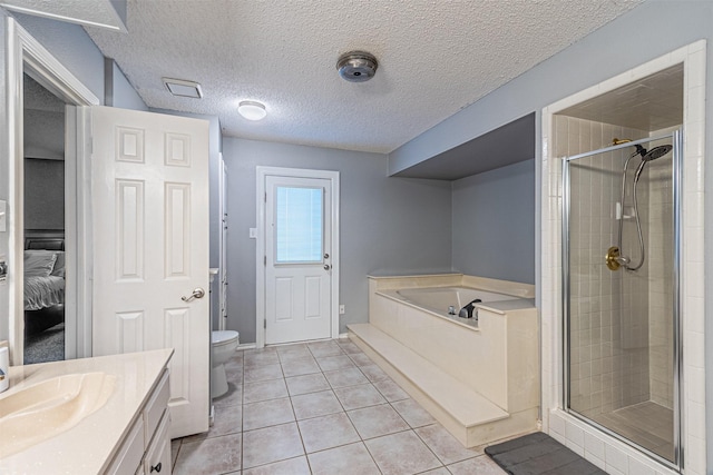 full bathroom with a textured ceiling, tile patterned floors, vanity, toilet, and separate shower and tub