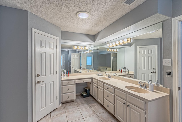 bathroom featuring a textured ceiling, tile patterned floors, and vanity