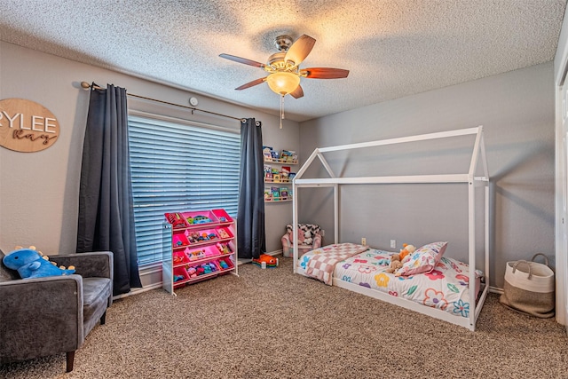 bedroom with ceiling fan, carpet floors, and a textured ceiling