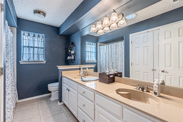 bathroom with tile patterned floors, a textured ceiling, toilet, and vanity