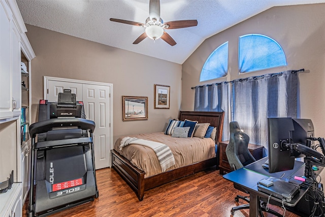 bedroom featuring ceiling fan, dark wood-type flooring, a textured ceiling, and lofted ceiling