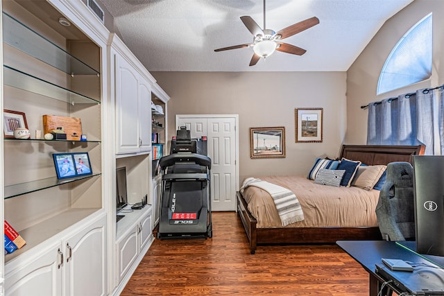 bedroom featuring ceiling fan, dark wood-type flooring, a textured ceiling, and a closet