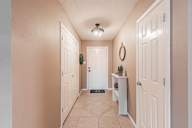 doorway with light tile patterned floors and a textured ceiling