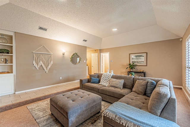 living room with vaulted ceiling, a textured ceiling, a tray ceiling, and built in shelves