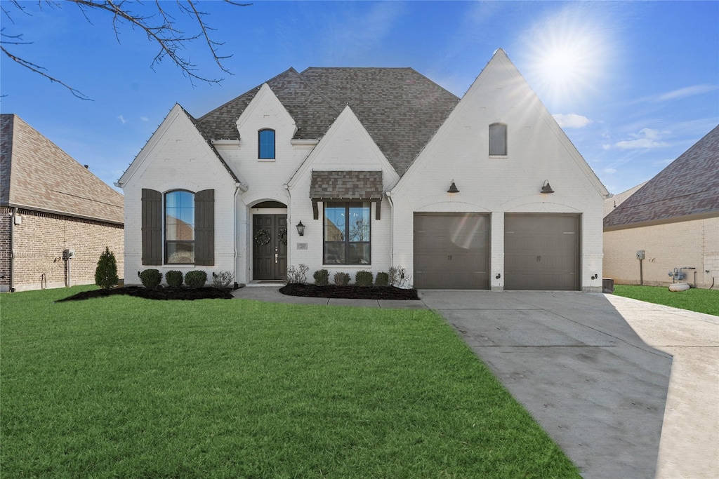 french country home with a front lawn and a garage