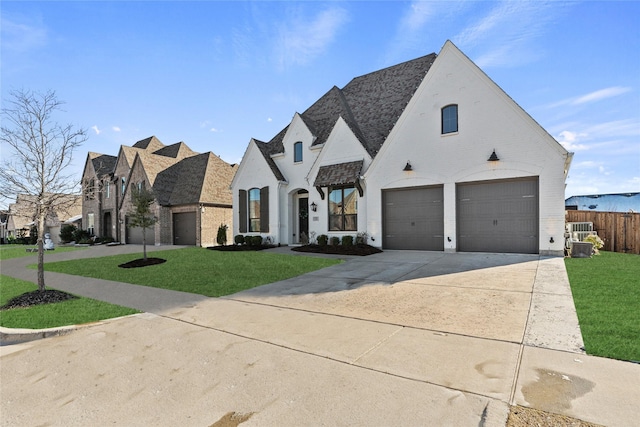 french country home with a garage and a front yard