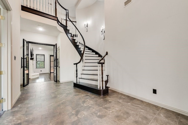 staircase featuring a towering ceiling