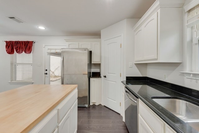 kitchen with stainless steel appliances, sink, butcher block countertops, and white cabinets