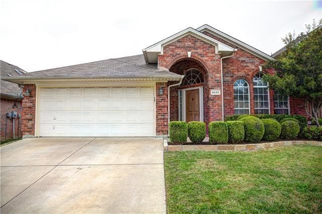 view of property featuring a front lawn and a garage