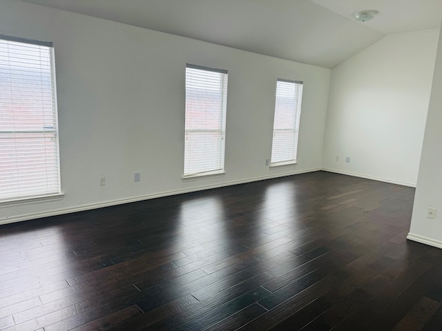 unfurnished room with dark wood-type flooring and vaulted ceiling