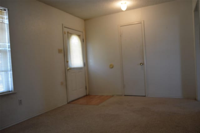 entryway with light colored carpet