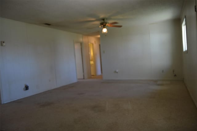 spare room featuring ceiling fan and carpet