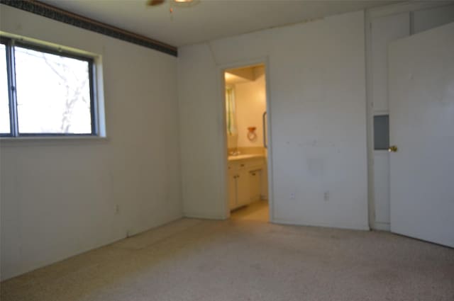 unfurnished bedroom with light colored carpet and connected bathroom