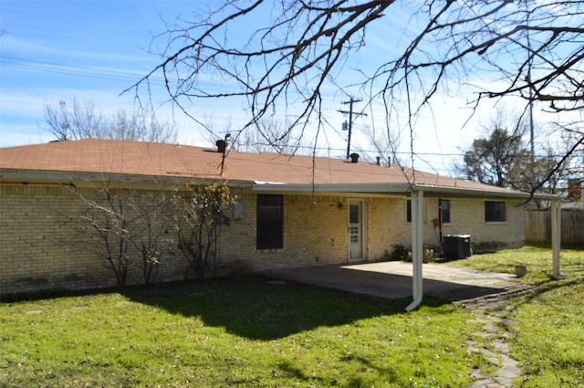 rear view of house featuring a lawn, central AC unit, and a patio area