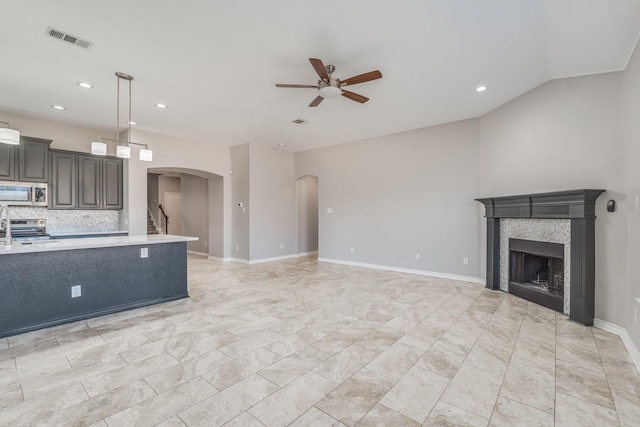 unfurnished living room with ceiling fan and a fireplace