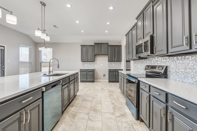 kitchen with gray cabinetry, sink, decorative backsplash, decorative light fixtures, and stainless steel appliances