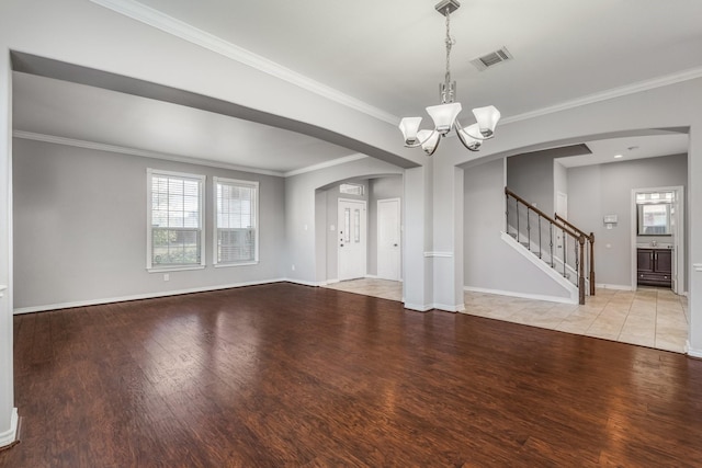 unfurnished living room with light hardwood / wood-style floors, crown molding, and a chandelier