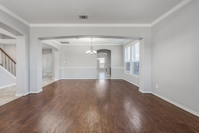 spare room with crown molding, dark hardwood / wood-style floors, and an inviting chandelier