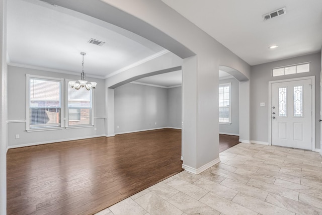 entryway featuring light tile patterned floors, a chandelier, and ornamental molding