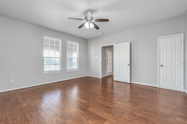 empty room with ceiling fan and dark wood-type flooring