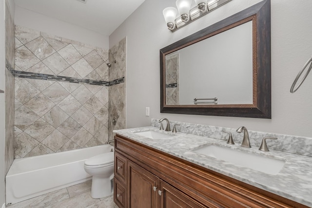 full bathroom with vanity, tiled shower / bath combo, and toilet