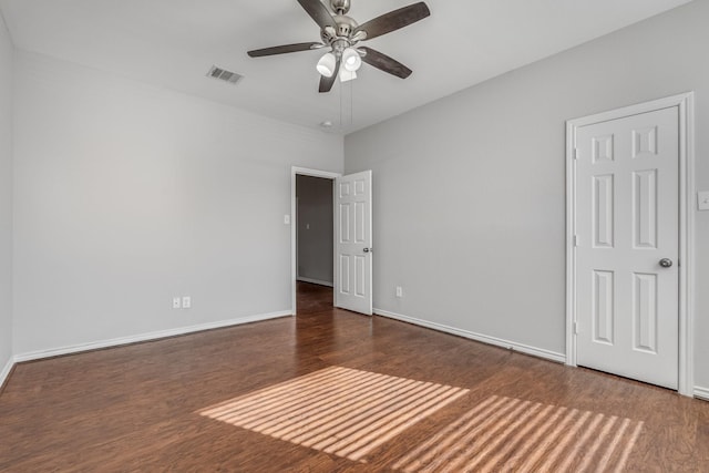 empty room featuring ceiling fan and dark wood-type flooring