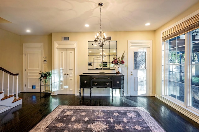 entrance foyer featuring an inviting chandelier and dark hardwood / wood-style floors