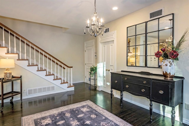 entryway with dark hardwood / wood-style floors and an inviting chandelier