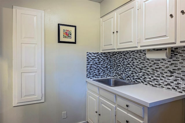 kitchen with white cabinetry, sink, and backsplash