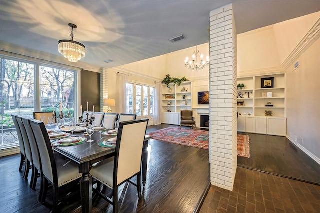 dining room featuring a fireplace, decorative columns, and a healthy amount of sunlight