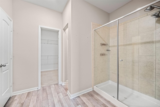 bathroom with hardwood / wood-style flooring and a shower with shower door