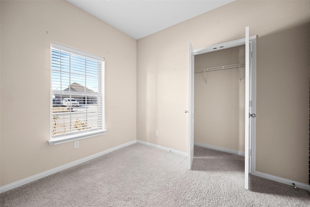 unfurnished bedroom with a closet and light colored carpet