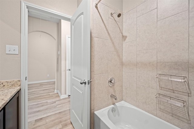 bathroom featuring hardwood / wood-style floors, tiled shower / bath combo, and vanity